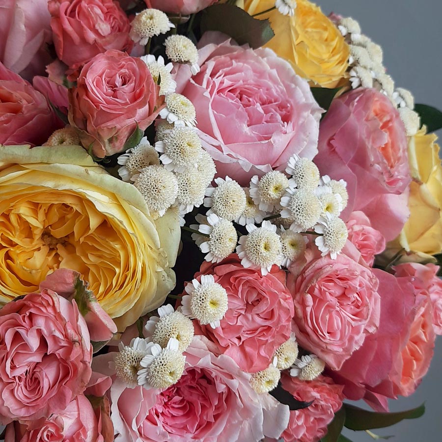 букет из розовых и желтых роз с белыми цветочками