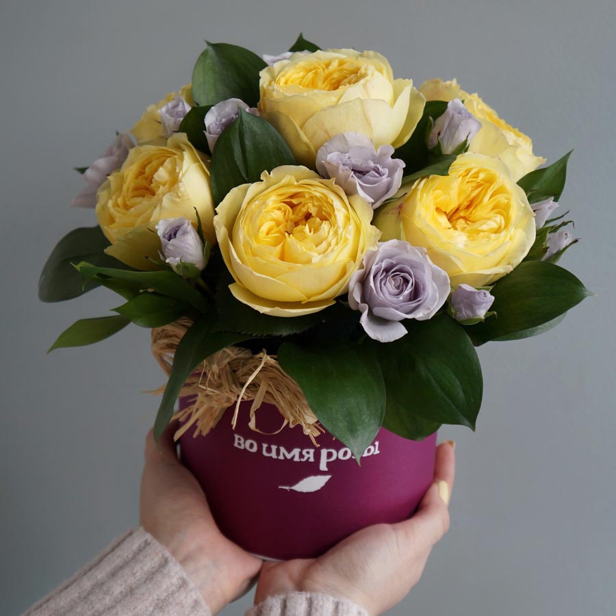 букет из желтых и фиолетовых роз в шляпной коробке с рукусом, декоративные листья в букетах название