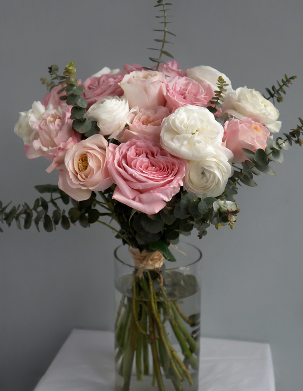 красивый букет из белых, розовых и кремовых роз в прозрачной вазе